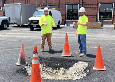 Prairie Contractors employees in front sink hole with caution cones